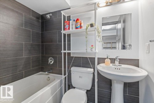 Bathroom featuring a white pedestal sink, a white toilet, and a white bathtub - 3 7210 96 Street, Edmonton, AB - Indoor Photo Showing Bathroom