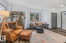 Living area featuring ample natural light, wood-finish flooring, white walls, and dark trim - 3 7210 96 Street, Edmonton, AB  - Indoor Photo Showing Living Room 