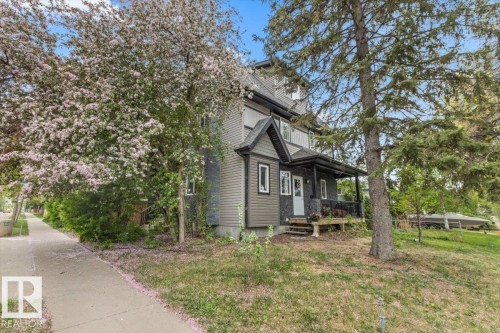Two-story residence featuring a covered front porch, dark gray siding, and white trim - 3 7210 96 Street, Edmonton, AB - Outdoor