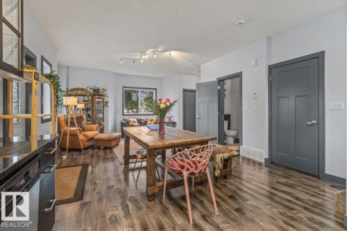 Open-concept living area featuring wood-finish flooring throughout, light-colored walls, and dark interior doors - 3 7210 96 Street, Edmonton, AB - Indoor Photo Showing Other Room