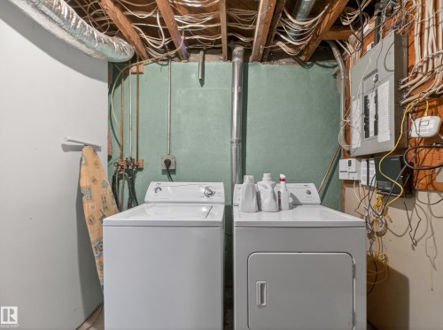 Dedicated laundry area featuring exposed ceiling joists and utility piping - 10809 150 Street, Edmonton, AB 