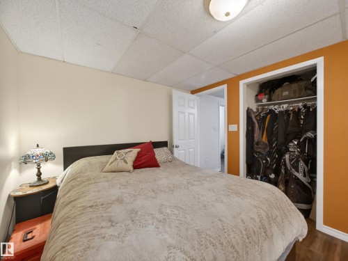 Bedroom featuring a drop ceiling, white walls, and a feature wall in orange - 10809 150 Street, Edmonton, AB 