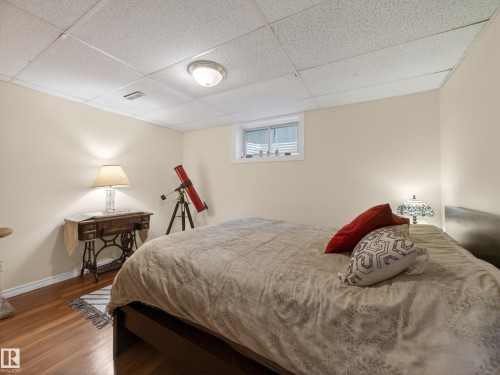 Room featuring wood-finish flooring, light-toned walls, and a drop ceiling with recessed lighting - 10809 150 Street, Edmonton, AB 