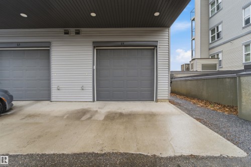 Individual garage featuring a gray sectional door with paneling - 64 655 Watt Boulevard, Edmonton, AB 