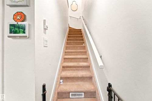 Carpeted staircase with white walls and a white handrail - 64 655 Watt Boulevard, Edmonton, AB 