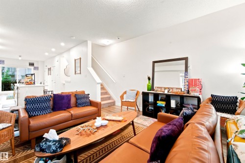 Open-concept living area with light wood-finish flooring and white walls - 64 655 Watt Boulevard, Edmonton, AB 