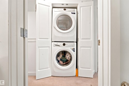 Dedicated laundry closet featuring a stacked washer and dryer unit - 64 655 Watt Boulevard, Edmonton, AB 