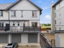 Multi-level residence featuring contemporary siding, private balcony, and an attached garage with overhead door - 64 655 Watt Boulevard, Edmonton, AB 