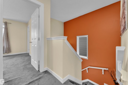 Carpeted hallway with white trim, a solid panel interior door, and a cream-colored wall - 2362 29A Avenue, Edmonton, AB 