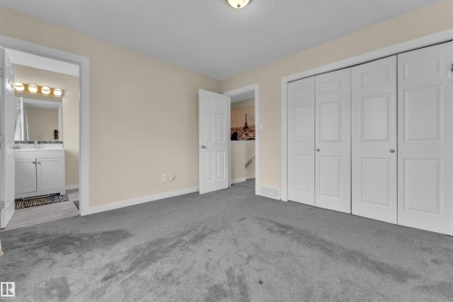 Carpeted room featuring light-toned walls and dual bi-fold closet doors - 2362 29A Avenue, Edmonton, AB 
