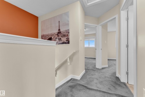 Upper level hallway featuring neutral wall paint, white trim, gray carpeting, and multiple doorways leading to additional rooms - 2362 29A Avenue, Edmonton, AB 