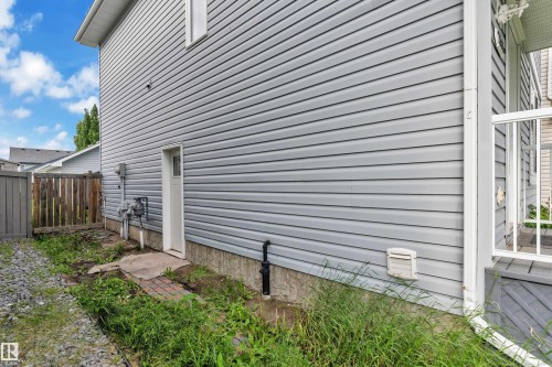 Grey vinyl siding exterior with white trim and a rear entrance door - 2362 29A Avenue, Edmonton, AB 