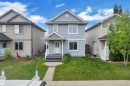 Light blue siding exterior featuring decorative gable trim, a covered porch with white railings, a white front door, and a concrete walkway - 2362 29A Avenue, Edmonton, AB 