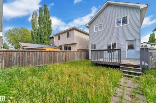 Rear exterior with light blue siding, a wooden deck, and a privacy fence - 2362 29A Avenue, Edmonton, AB 