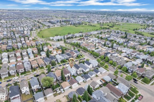 Aerial view of a residential neighborhood with detached homes, mature trees, and a green space visible in the background - 2362 29A Avenue, Edmonton, AB 