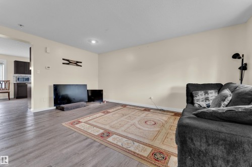 Spacious living area featuring wood-finish flooring, recessed lighting, and a neutral color palette - 2362 29A Avenue, Edmonton, AB 