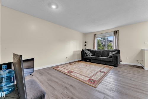 Living area featuring neutral-toned walls, recessed lighting, and wood-finish flooring - 2362 29A Avenue, Edmonton, AB 