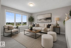 Bright living area featuring large picture windows, a neutral color palette, ceiling lighting, and soft carpet flooring - 