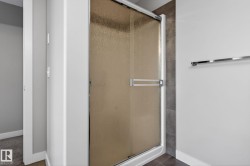 Enclosed shower with textured glass door and chrome hardware - 