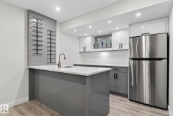 Kitchenette featuring a stainless steel refrigerator and wood-finish flooring - 