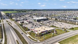 Aerial perspective showcasing a commercial center with a large surface parking lot - 