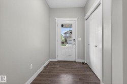Entryway featuring wood-finish flooring, light gray walls, and white baseboards - 