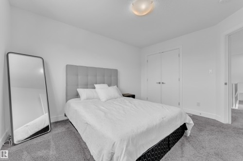 Bedroom featuring plush gray carpeting, white walls, and a ceiling-mounted light fixture - 2630 16A Avenue, Edmonton, AB 