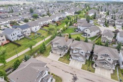Aerial perspective of a contemporary residential neighborhood featuring uniform roofing and established landscaping - 