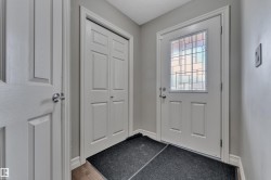 Entryway featuring a white paneled door with a decorative glass insert, complemented by a bi-fold closet door - 