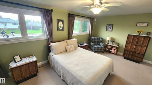 Spacious room featuring multiple windows, light green walls, and neutral-toned carpeting - 13307 Delwood Road, Edmonton, AB 