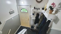 Entryway featuring a white door with an arched glass panel and brass hardware - 