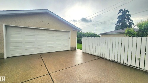 Attached garage featuring a white paneled door and stucco exterior - 13307 Delwood Road, Edmonton, AB 