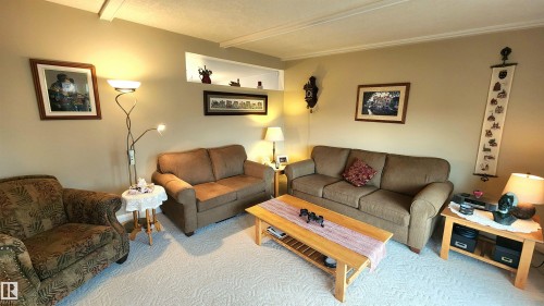 Carpeted living area featuring neutral wall tones and crown molding - 13307 Delwood Road, Edmonton, AB 