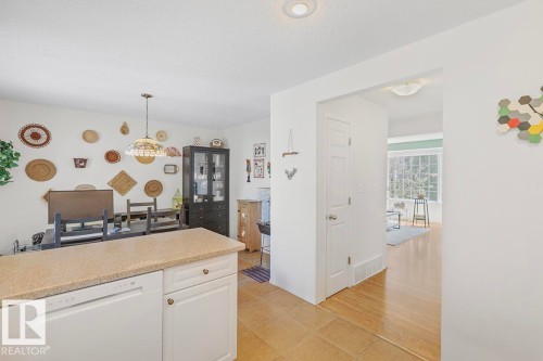 Kitchen island with light-toned countertop and integrated dishwasher - 44 9630 176 Street, Edmonton, AB 