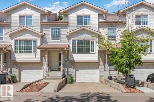 Light-colored siding exterior featuring multiple bay windows and individual garages - 44 9630 176 Street, Edmonton, AB 