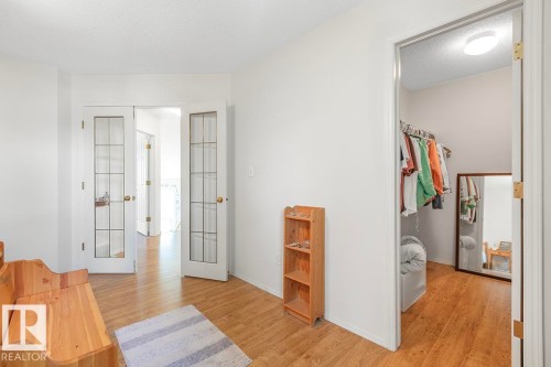 Interior space with wood-finish flooring, white walls, and a recessed ceiling light - 44 9630 176 Street, Edmonton, AB 