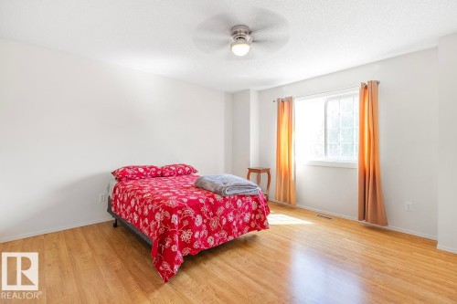 Light-filled interior space featuring wood-finish flooring, a window with curtains, and a ceiling fan with integrated lighting - 44 9630 176 Street, Edmonton, AB 