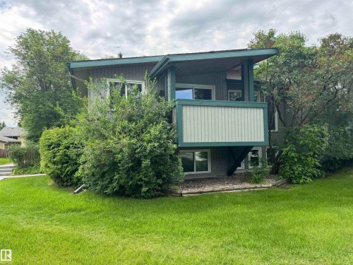 Split-level residence featuring a prominent upper-level balcony with vertical paneling - 6441 180 Street, Edmonton, AB 