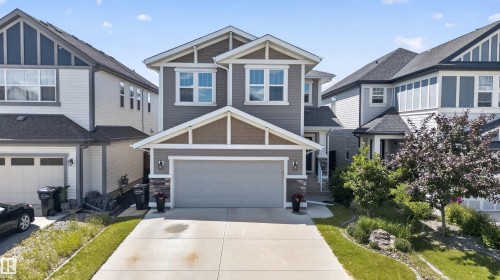 Two-story residence featuring a neutral grey siding exterior with contrasting brown gables and white trim - 9432 229 Street, Edmonton, AB 