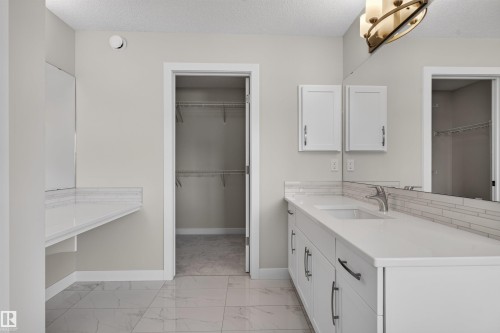 Bathroom vanity with dual sinks, white cabinetry, and extensive countertop space - 9432 229 Street, Edmonton, AB 