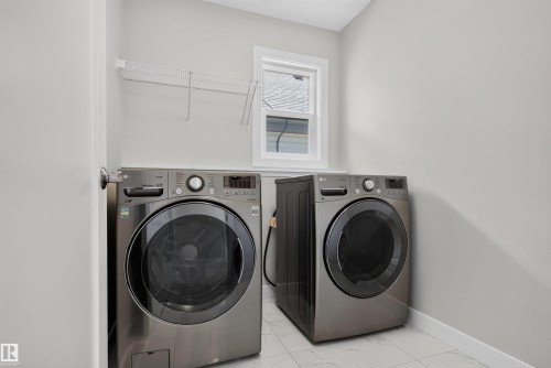 Laundry area featuring a window, tile flooring, and a wire storage shelf - 9432 229 Street, Edmonton, AB 
