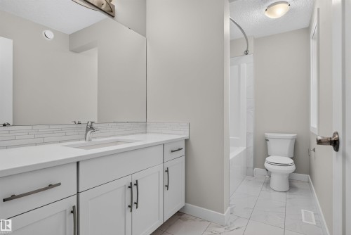 Vanity with white shaker cabinetry, quartz-finish countertop, and undermount sink - 9432 229 Street, Edmonton, AB 