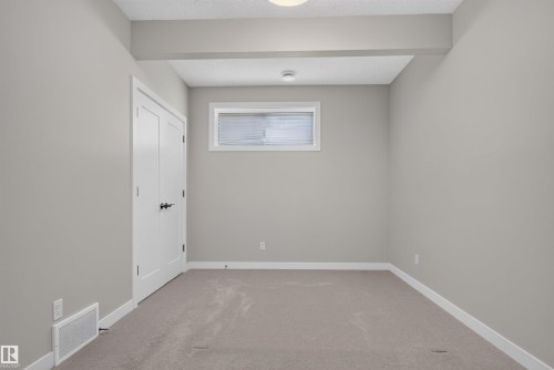 Room featuring neutral tone walls, light-colored carpeting, and white trim - 9432 229 Street, Edmonton, AB 