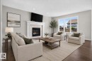 Living area featuring a gas fireplace with a decorative tile surround and white wood mantel - 9432 229 Street, Edmonton, AB 
