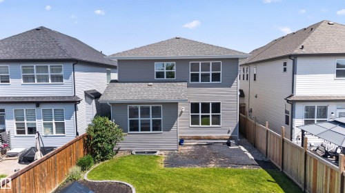 Rear exterior featuring gray siding, multiple windows, and a shingled roof - 9432 229 Street, Edmonton, AB 