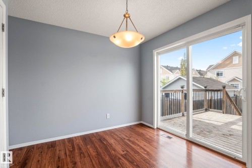 Room featuring wood-finish flooring, light gray walls, and a contemporary ceiling fixture - 7118 19A, Edmonton, AB - Indoor Photo Showing Other Room