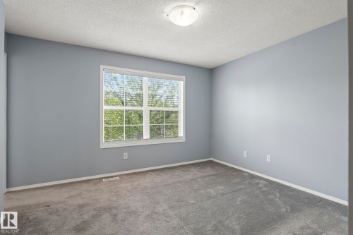 Spacious room featuring light blue walls, gray carpeting, and white trim - 7118 19A, Edmonton, AB - Indoor Photo Showing Other Room