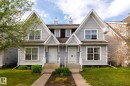 Duplex exterior featuring light gray horizontal siding, white trim, gabled roofs, and individual front entrances with concrete walkways - 7118 19A, Edmonton, AB  - Outdoor With Facade 