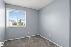 Interior space featuring light gray walls, white trim, and gray carpet - 