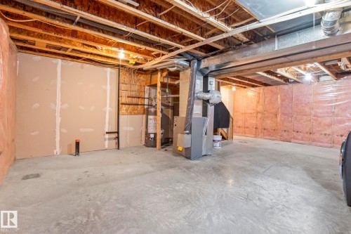 Unfinished basement featuring exposed wood joists, concrete flooring, and visible HVAC ductwork - 7118 19A, Edmonton, AB - Indoor Photo Showing Basement
